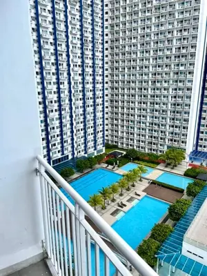 a balcony of a large building with a swimming pool at Jazz Residences Makati Tower B in Manila