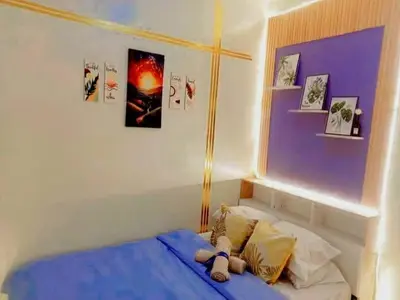 a bedroom with a blue bed with pictures on the wall at Dream City Staycation -Shore3 Residences Tower 2 in Manila