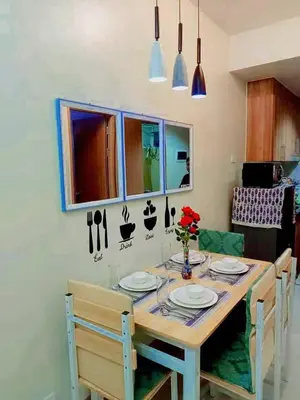 a dining room table with plates and flowers on it at Dream City Staycation -Shore3 Residences Tower 2 in Manila