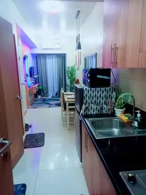 a kitchen with a sink and a table in a room at Dream City Staycation -Shore3 Residences Tower 2 in Manila