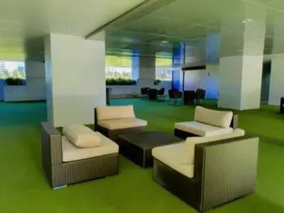 a living room with couches and a green floor at Dream City Staycation -Shore3 Residences Tower 2 in Manila