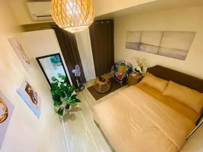 a room with a bed and a chair in it at Sole Sisters Staycation in Manila