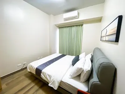 a bedroom with a bed with a couch and a window at Cozy 3BR near Airport & Okada, Solaire II Infinity Pool in Manila