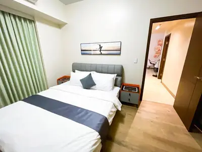 a hotel room with a bed and a hallway at Cozy 3BR near Airport & Okada, Solaire II Infinity Pool in Manila
