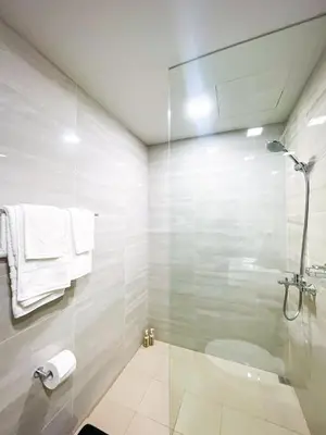 a bathroom with a glass shower and a toilet at Cozy 3BR near Airport & Okada, Solaire II Infinity Pool in Manila