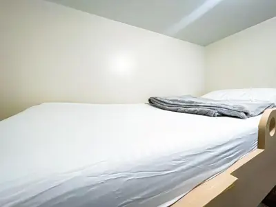 a white bed in a white room with a blanket on it at Cozy 2BR Suite near Airport & Okada, Infinity Pool in Manila