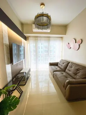 a living room with a couch and a television at Cozy 2BR Suite near Airport & Okada, Infinity Pool in Manila