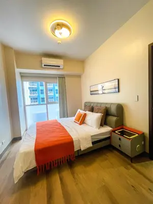 a bedroom with a large bed with a window at Cozy 2BR Suite near Airport & Okada, Infinity Pool in Manila