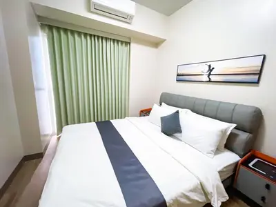 a bedroom with a bed with a tie on it at Spacious 1BR Suite near Okada, Solaire, Airport in Manila