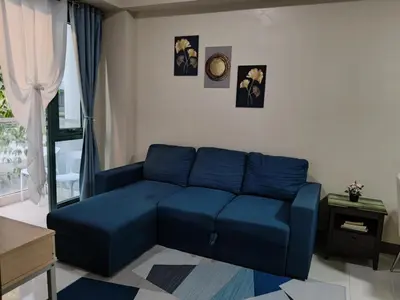 a blue couch sitting in a living room at LDN Two Palm Tree Villa LFamilia in Manila