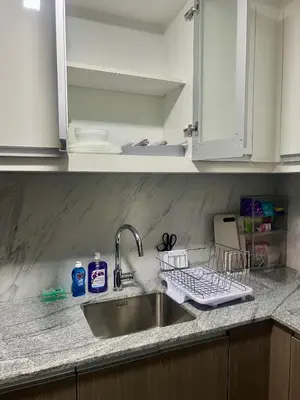a kitchen sink with a dish drying rack next to it at 1 BR Executive Suite Gentry Manor by JMS in Manila