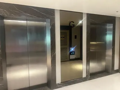 an elevator lobby with stainless steel walls and mirrors at 1 BR Executive Suite Gentry Manor by JMS in Manila