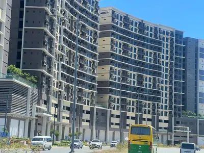 a yellow van parked in front of a tall building at 1 BR Executive Suite Gentry Manor by JMS in Manila
