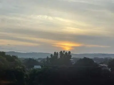 a sunset in the sky over a city with trees at Charm Residences Building E in Manila