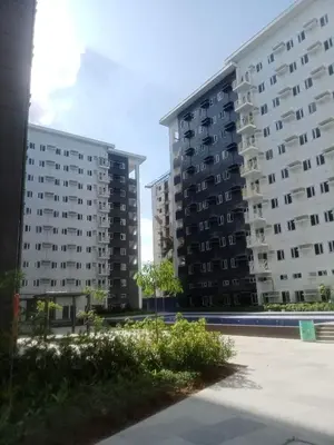 two tall apartment buildings in a parking lot at Charm Residences Building E in Manila