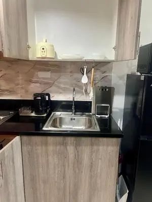 a kitchen with a sink and a refrigerator at 1 Br Family Suite in S Residences by JMS in Manila