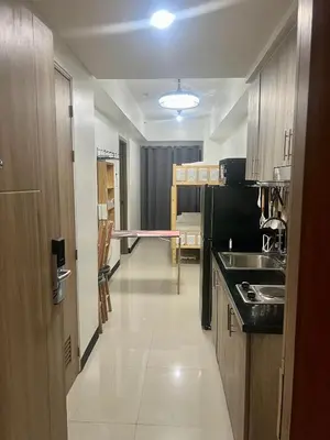 a small kitchen with a sink and a table at 1 Br Family Suite in S Residences by JMS in Manila