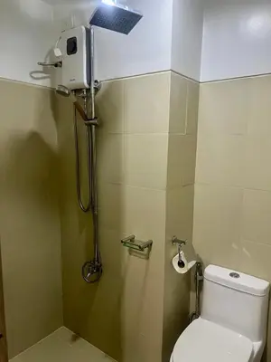 a small bathroom with a toilet and a shower at 1 Br Family Suite in S Residences by JMS in Manila
