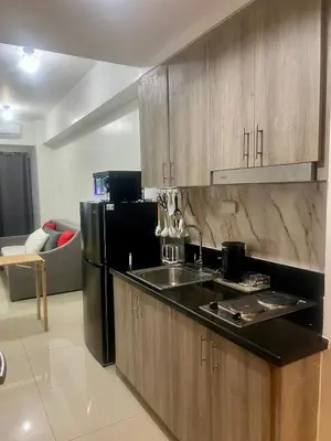 a kitchen with a black refrigerator and a sink at 1 Br Family Suite in S Residences by JMS in Manila