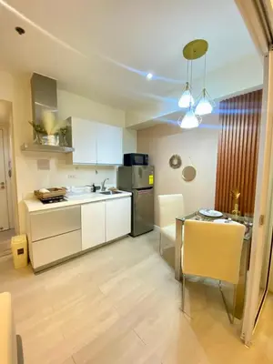 a kitchen with white cabinets and a table at Azure Staycation PH 1503 in Manila