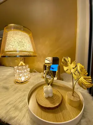 a table with a lamp and a plate with a flower on it at Azure Staycation PH 1503 in Manila