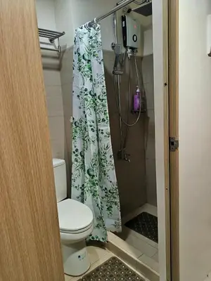 a bathroom with a toilet and a shower curtain at Shore Residences MOA Minimalist Room in Manila