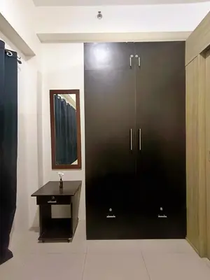 a bathroom with a black door and a table at Shore Residences MOA Minimalist Room in Manila