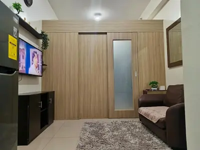 a living room with a couch and a flat screen tv at Shore Residences MOA Minimalist Room in Manila
