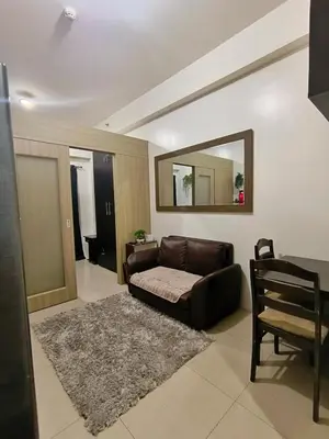 a living room with a couch and a mirror at Shore Residences MOA Minimalist Room in Manila