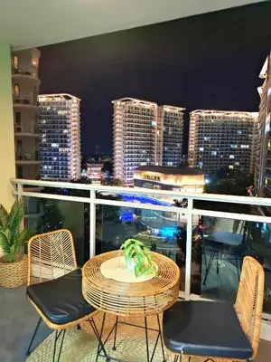 a table and chairs on a balcony with a city skyline at Azure Condotel and Resort in the City in Manila
