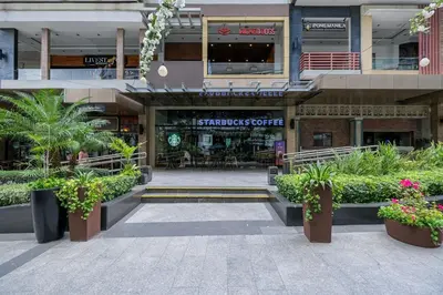 a shopping center with plants in front of a building at Cozy 2BR Suite in Uptown BGC with PS4 and walking distance to Malls and Restaurants in Manila