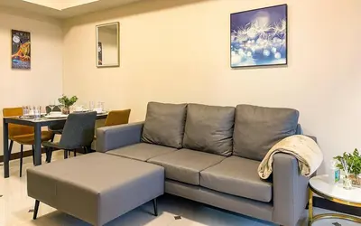 a living room with a couch and a table at Cozy 2BR Suite in Uptown BGC with PS4 and walking distance to Malls and Restaurants in Manila