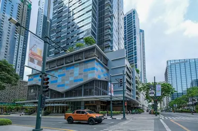 an orange truck parked in front of a building at Spacious 3BR Suite in Uptown BGC with King Size Bed, near Malls and Restaurants in Manila