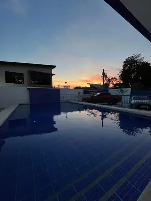 a swimming pool with a sunset in the background at Private Resort in upper Antipolo in Antipolo