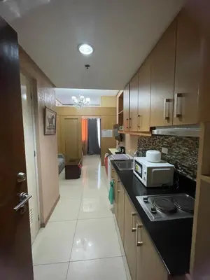 a kitchen with wooden cabinets and a counter top at 1528 pool view with balcony in Manila