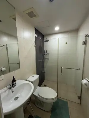 a bathroom with a toilet and a sink and a shower at Palms Paradise with the best view of BGC plus Netflix in Manila