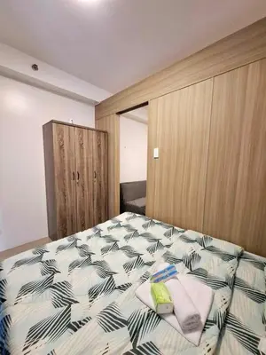a bedroom with a bed with towels on it at Wooden style amenities view in Manila