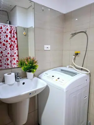 a bathroom with a sink and a toilet and a mirror at Wooden style amenities view in Manila