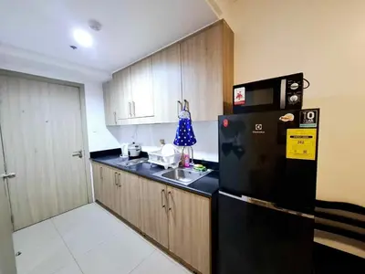 a kitchen with a black refrigerator and a sink at Wooden style amenities view in Manila
