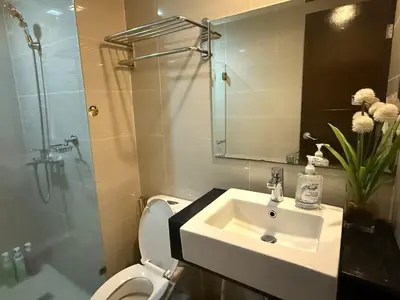 a bathroom with a sink and a toilet and a shower at Deluxe Suite in Venice Mall in Manila