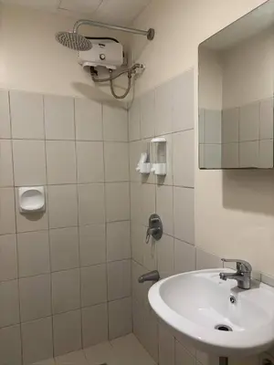 a white bathroom with a sink and a mirror at Bless View at 16th in Manila