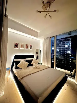 a bedroom with a large bed and a large window at Cozy Condo near Manila Airport in Manila