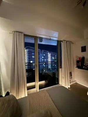 a bedroom with a window with a view of a city at Cozy Condo near Manila Airport in Manila