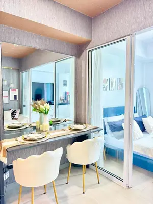 a dining room with a table and chairs and a bedroom at Cozy Condo near Manila Airport in Manila
