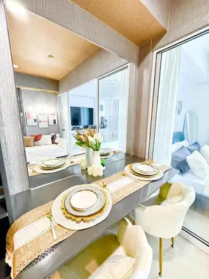 a dining room with a table with plates on it at Cozy Condo near Manila Airport in Manila
