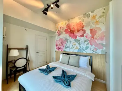 a bedroom with a bed with blue bows on it at Spacious Tropics with Golf View in BGC in Manila