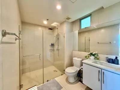 a bathroom with a shower and a toilet and a sink at Spacious Tropics with Golf View in BGC in Manila