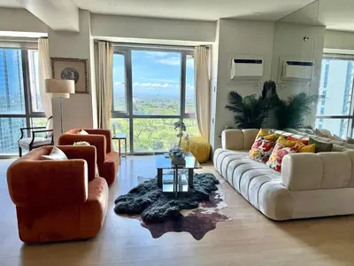 a living room with a couch and two chairs at Spacious Tropics with Golf View in BGC in Manila