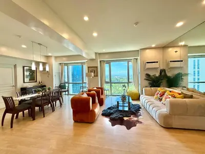 a large living room with a couch and a table at Spacious Tropics with Golf View in BGC in Manila
