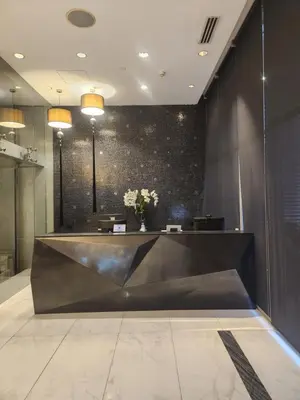 a lobby with a black wall with flowers on it at Azure Staycation Philippines by AMRS Near Manila International Airport in Manila